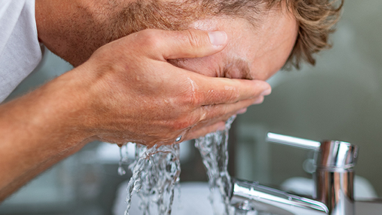 man washing face