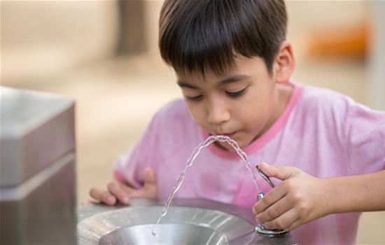 kid drinking from water fountain