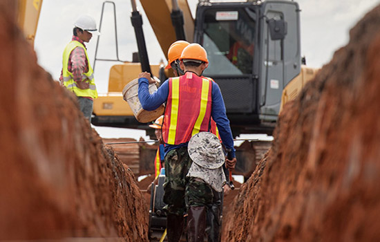 workers building pipe trench