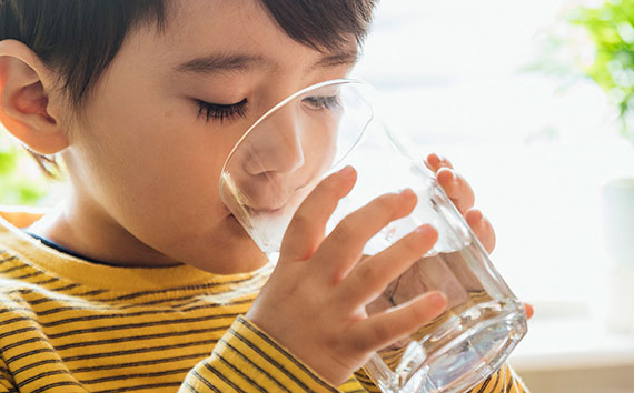small child drinking a glass of water