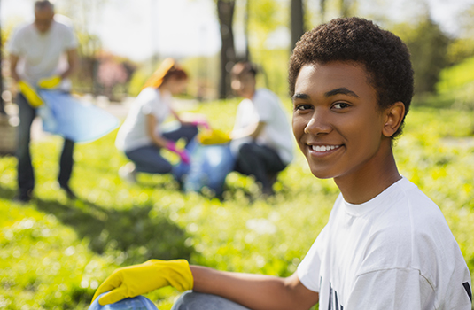 smiling young man at trash cleanup
