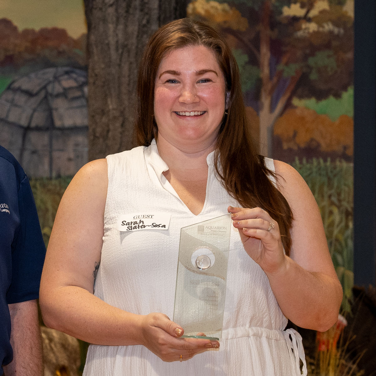 Sarah Slater-Sosa holding her 2023 Aquarion Environmental Champion award