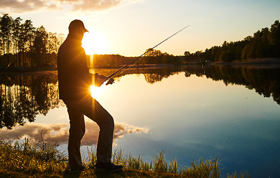 silhouette of man fishing at sunset