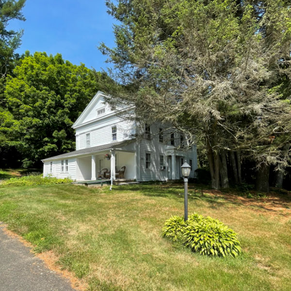 front lawn of white, 1800s colonial house